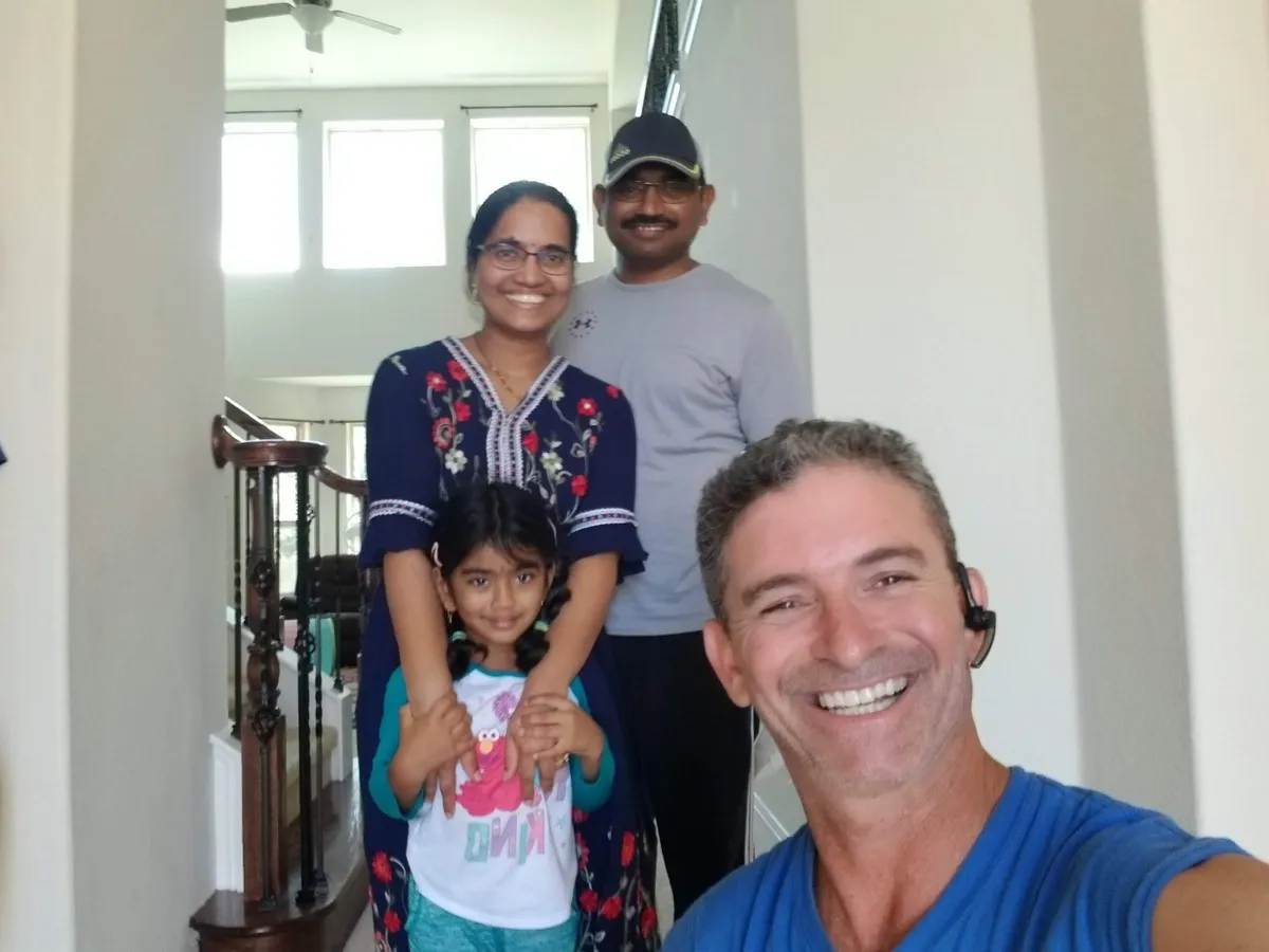A family in their new home with their Moving Pro Inc mover after move-in day